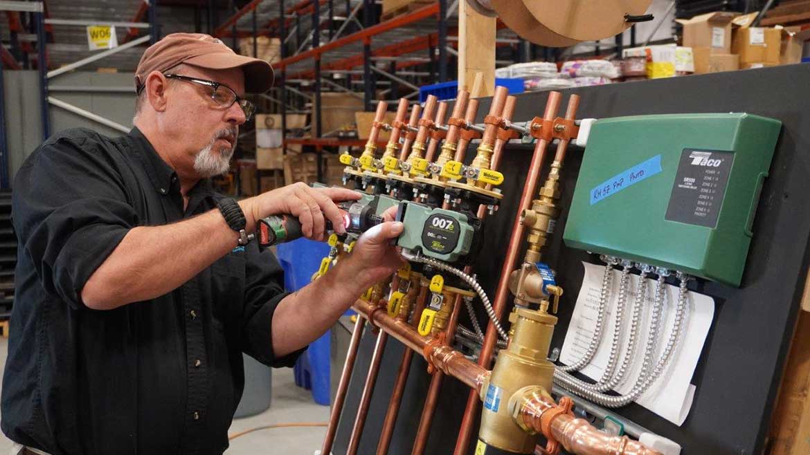 05 PM 1223 FW Webb feature. Jeff Hutchins, boiler board technician, completes wiring for a five-zone boiler board using Taco 007e circulators.